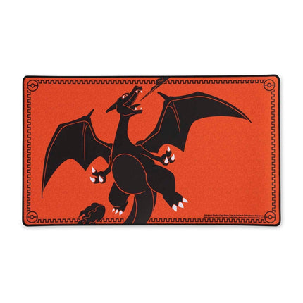 Playmat premium de Charizard con diseño de llamas, borde bordado y base antideslizante con patrón de Poké Ball.