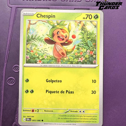 Carta individual Pokémon Chespin 005/086 común, Basic, set ME4 Chaos Rising. Ilustración alegre de Chespin en un bosque iluminado por el sol, por HACCAN - Thunder Cards México.
