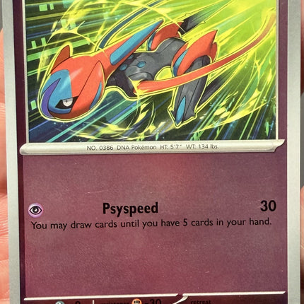 Carta individual Pokémon Deoxys Reverse 034/086, rareza infrecuente, Basic Pokémon, 100 HP, set Chaos Rising (CRI). Ilustración dinámica de Deoxys en Forma Velocidad cruzando una zona cibernética con destellos verdes por hncl - Thunder Cards México.